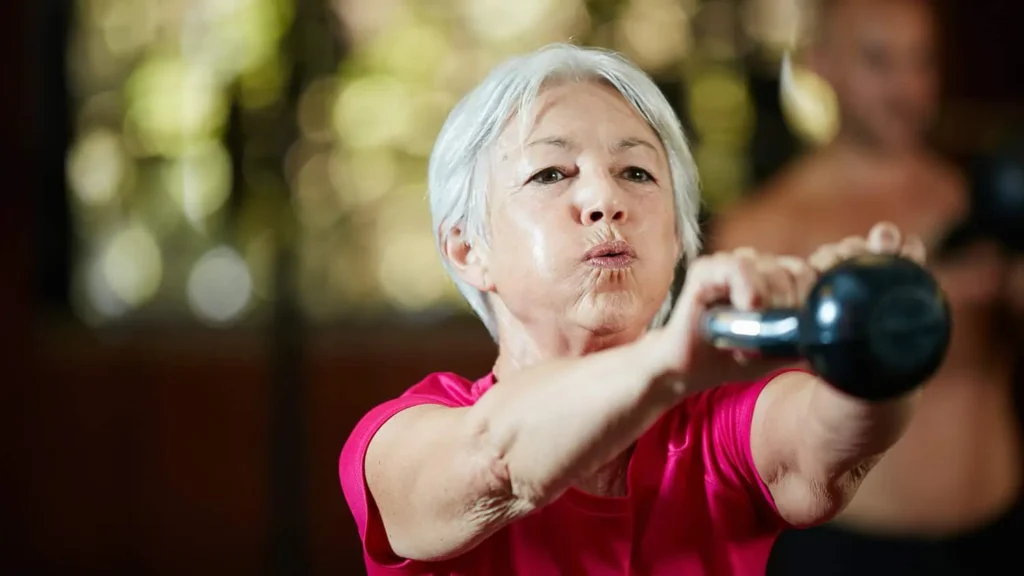 Toning Arms Without the Bulk: Is It Achievable? 1 Woman doing resistance band exercises for toned arms Isle of Isla