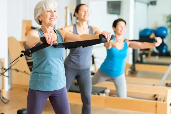 Toning Arms After 60: Empowering Womens Fitness Through Effective Weight Training 2 older woman doing weight training Isle of Isla and resistance in the gym to tone upper arms